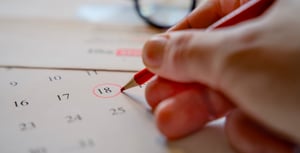 A person circling the 18th on a calendar